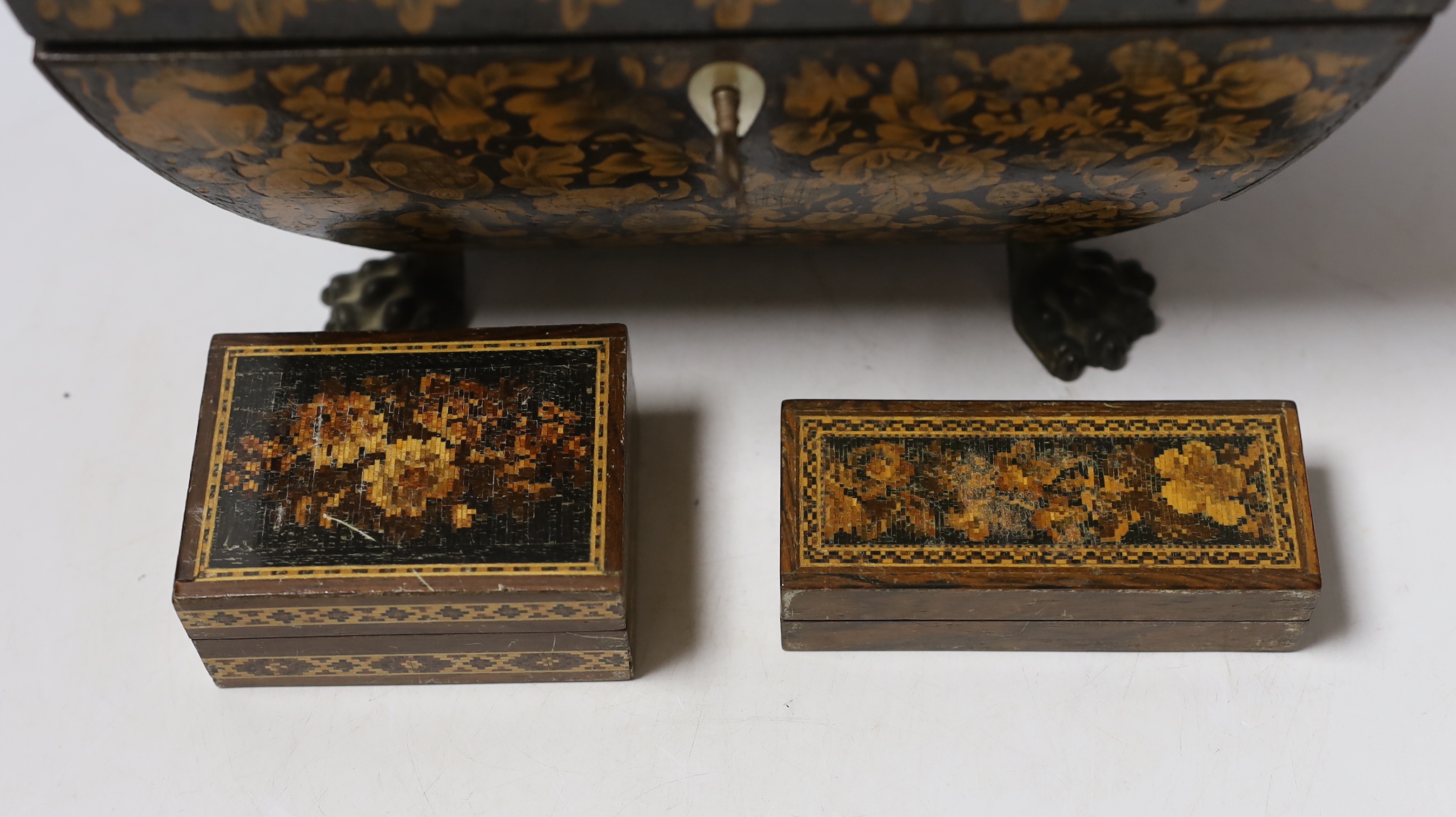 A Regency penwork tea caddy, the cover inset with an engraving of figures by a castle, 23.5 x 16 x 16cm and two small Tunbridge ware boxes